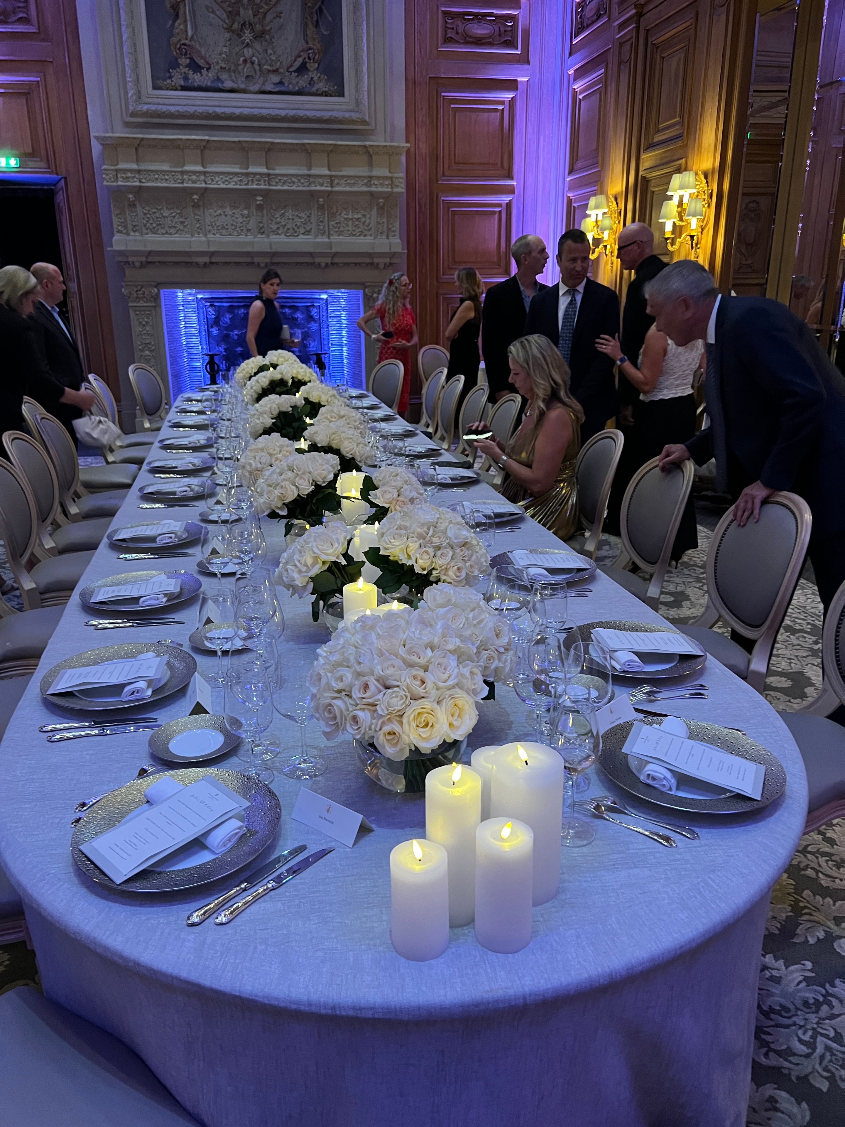 Formal event venue with white floral centerpieces and candlelight
