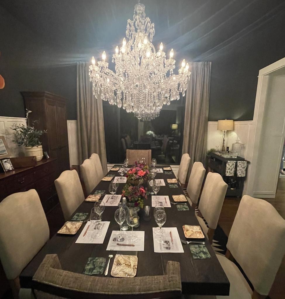 Elegant dining room with crystal chandelier and formal place settings